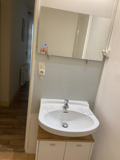 Lavabo blanc moderne avec miroir et mur carrelé dans l'appartement Hôtel De La Bonnheur, Bracieux