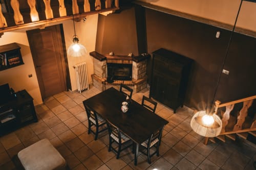 Acogedor comedor de Casa Rural Sensaciones con chimenea, vigas de madera e iluminación cálida en Cuevas de Viñayo