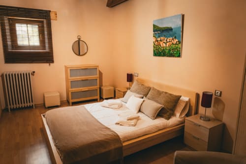 Acogedora habitación en Casa Rural Sensaciones con cama de madera, decoración beige cálida y pintura de paisaje rural