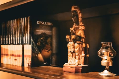 Figurita decorativa de madera y vasija de cristal exhibidas en la galería de Casa Rural Sensaciones, hotel de lujo
