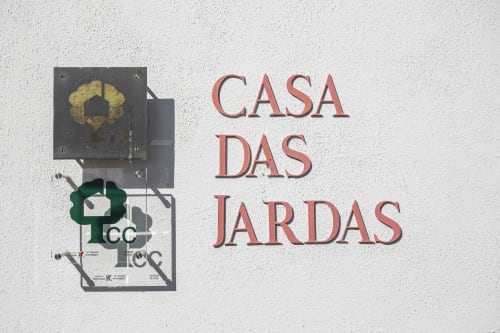 Cartel de Casa das Jardas con corona y logo en pared blanca en alojamiento rural de Ladoeiro, Portugal