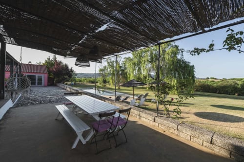 Patio exterior de Casa das Jardas con mesa de picnic blanca, zona de sombra y vistas del paisaje rural portugués