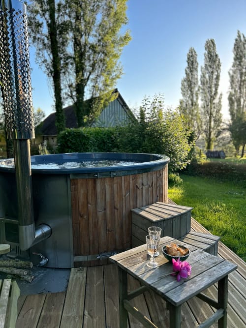 Hot tub with wooden deck at Domaine de Blanvatel, Saint Pierre en Auge, France, surrounded by poplar trees