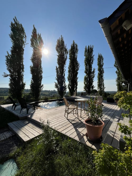 Rooftop terrace at Domaine de Blanvatel with pool, lounging area, and views of Saint Pierre en Auge countryside