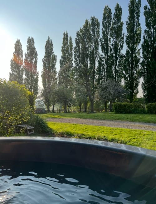 Poplar trees line the grounds at Domaine de Blanvatel B&B in Saint Pierre en Auge, with a pond in foreground