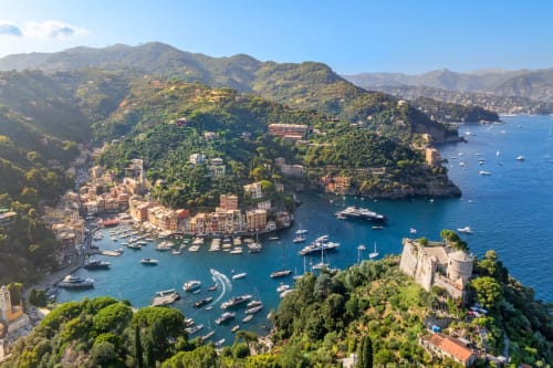 Vista aerea dell'Hotel Bel Sit a Rapallo con porto colorato, barche e verdi montagne sullo sfondo