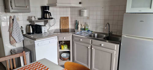 Coin cuisine de la chambre 313 au Vue D'ici B&B à Saint Valéry sur Somme, équipé d'une cuisinière, évier, réfrigérateur et table à manger