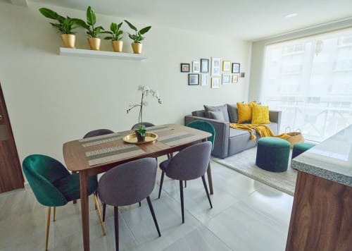 Apartamento moderno en CDMX de Pares Homes con mesa de comedor, sofá gris, acentos turquesa y plantas en macetas