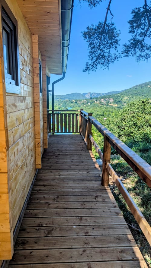 Terrazza in legno del Lodge Le Chamois con vista sulle montagne e il fiume a Serrières-sur-Ain, Francia