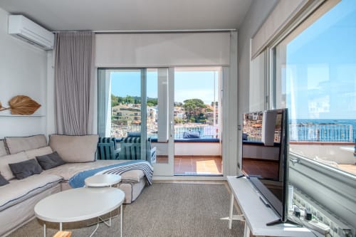 Bright sea-view apartment bedroom in Palafrugell with balcony overlooking coastal town and Mediterranean Sea, modern
