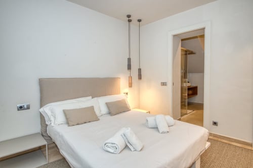Modern bedroom in Casa dins el Mar, Palafrugell with sea view. King bed, pendant lights, ensuite bathroom access.