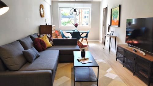 Moderno apartamento en Baiona con sofá gris, comedor, TV de pantalla plana y vistas a la ciudad desde amplio ventanal