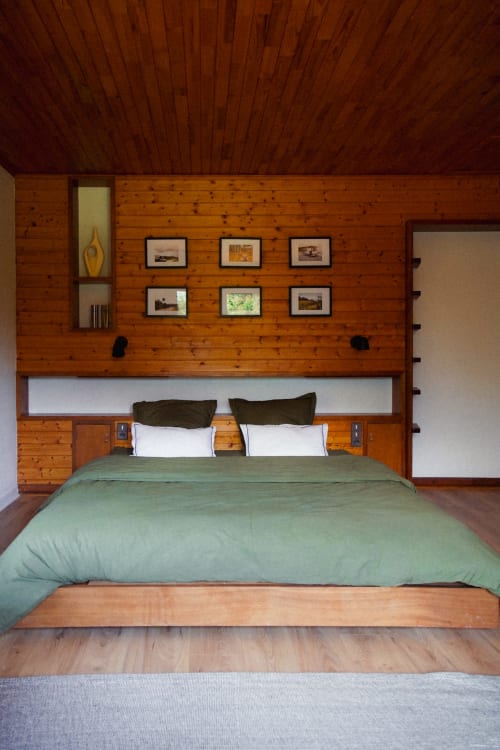 Vue de l'intérieur de la chambre "Verte" : lit king size et photos de famille