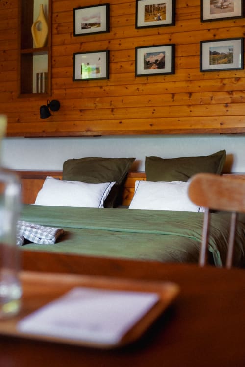 Lit king size dans la chambre verte et photos de famille