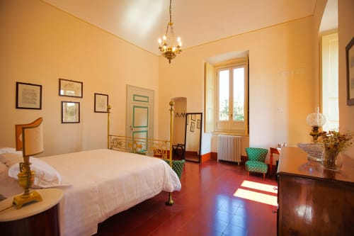 Camera Nietta, suite deluxe con letto king size a Villa Ceci ad Andria, pareti gialle, pavimento in cotto rosso e vista sul giardino
