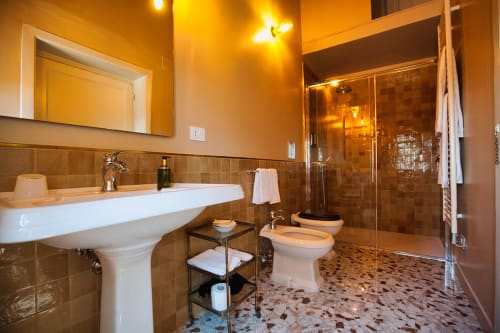 Lussuoso bagno di Villa Ceci ad Andria con lavabo a colonna, wc, doccia walk-in e tonalità dorate