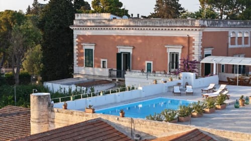 Villa Ceci in terracotta con piscina blu, lettini e vista sulla campagna di Andria al tramonto
