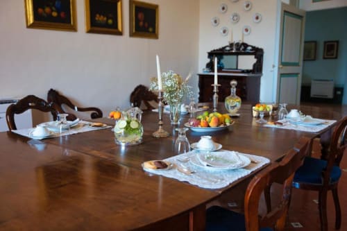 Elegante sala da pranzo della Villa Ceci B&B ad Andria con tavolo apparecchiato, fiori freschi, candele e composizioni di frutta