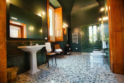 Ampio bagno di Villa Ceci B&B ad Andria con pareti verde scuro, lavabo su colonna, doccia a cascata e pavimento in terrazzo.