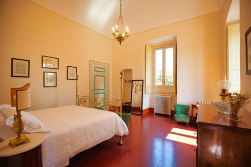 Spaziosa camera da letto a Villa Ceci B&B ad Andria, Italia, con letto bianco, pareti gialle, pavimento in cotto e arredamento classico