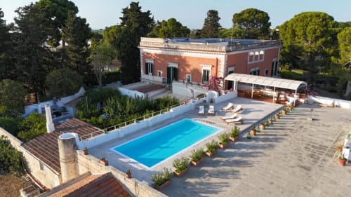 Vista aerea di Villa Ceci B&B ad Andria con villa rossa, piscina blu, terrazza, lettini e giardini