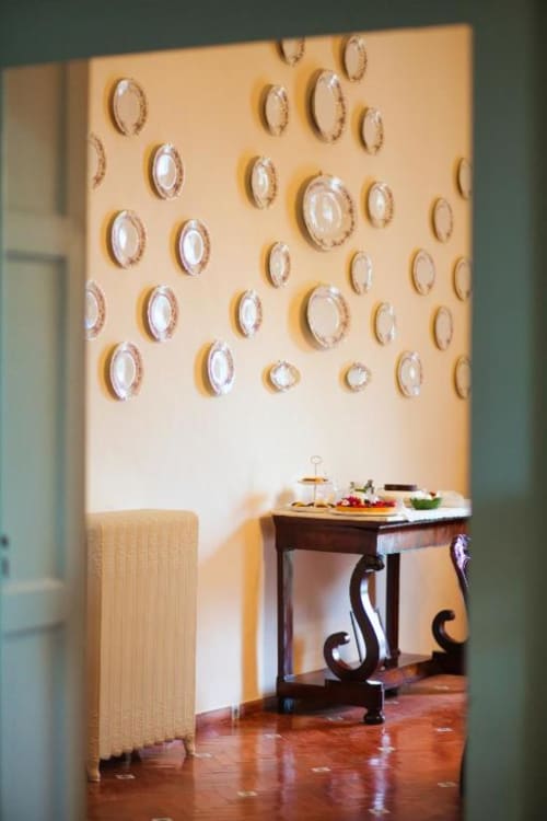 Parete color crema decorata con piatti ornamentali nella cottage Villa Ceci B&B ad Andria, Italia