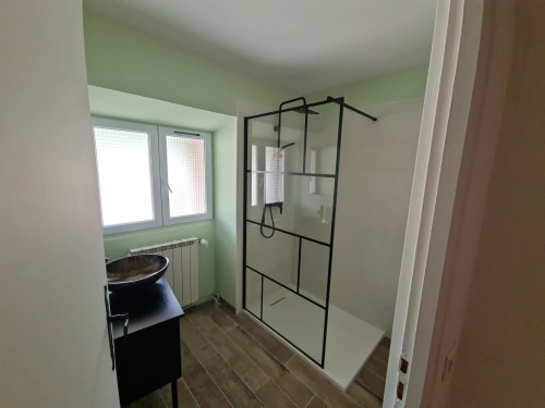 Bagno moderno con doccia a filo pavimento, lavabo e radiatore presso la Chambre d'hôtes Gîte Le Tilleul a Le Martinet