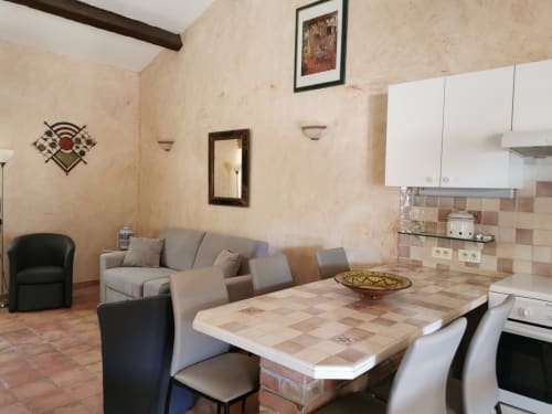 Cucina a pianta aperta e zona pranzo del Gîte Le Tilleul con pavimenti in cotto, tavolo da pranzo e comodi sedili