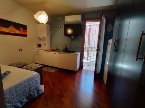 Modern mini apartment studio at Casa Meravigliosa with bed, kitchenette, TV, and garden view balcony in Fontanafredda,