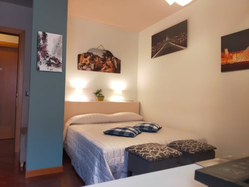 Cozy bedroom at Casa Meravigliosa with bed, pillows, bedside lamps, and framed wall art in Fontanafredda