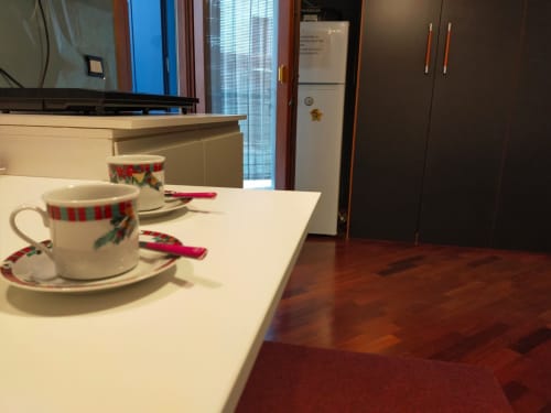 Bancone cucina moderno a Casa Meravigliosa con tazze decorative, frigorifero e mobili scuri a Fontanafredda