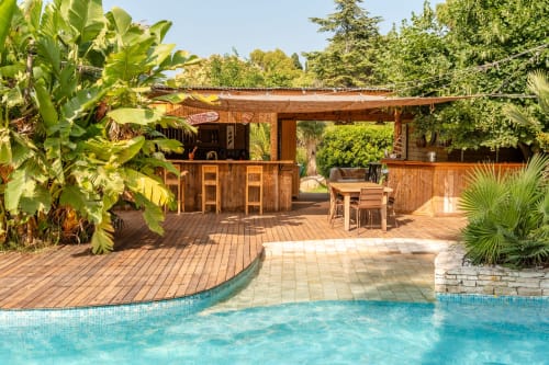 Poolhouse et piscine extérieure bordée de palmiers — maison de vacances avec piscine partagée à Hyères, dans le sud de la France.