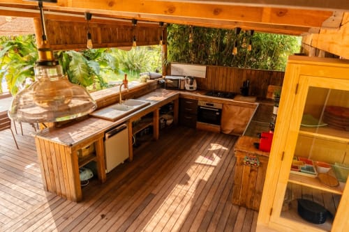 Cuisine d’été équipée et espace repas extérieur, idéale pour les séjours en groupe dans le sud de la France.
