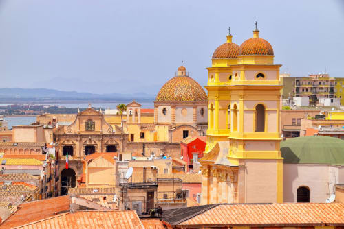 Chiese barocche colorate e tetti in terracotta a Cagliari. Ubicazione Bluemoon Sardinia BnB.