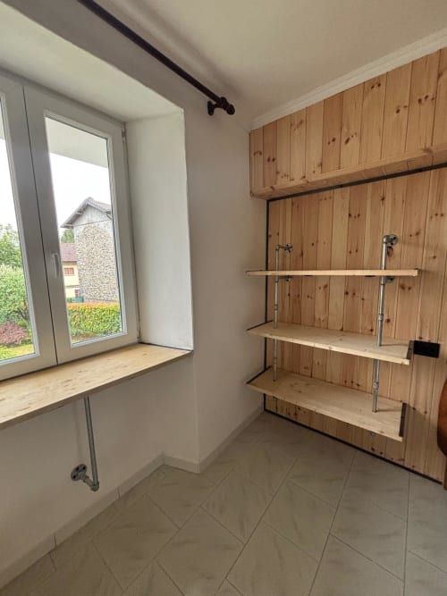 Angolo cottura dell'appartamento Sormano 3 con ripiani in legno, piano cottura a gas e vista sul giardino