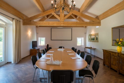 L'Amiradou meeting room with exposed beams, oval table, projection screen in Félines-sur-Rimandoule