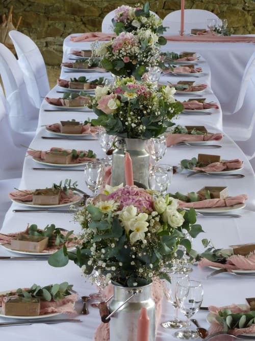 Elegant wedding reception table at L'Amiradou with pink floral centerpieces, white linens, and place settings,