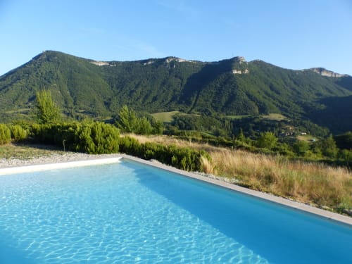 Infinity pool overlooking forested mountains at L'Amiradou B&B in Félines-sur-Rimandoule, France