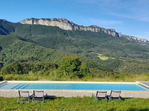 L'Amiradou BnB pool overlooking Félines-sur-Rimandoule with dramatic cliff mountains and forest