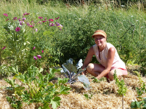 Woman gardening at L'Amiradou B&B in Félines-sur-Rimandoule, tending vegetables and pink flowers
