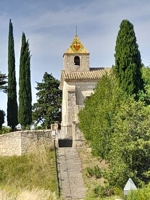 Stone chapel with golden roof at L'Amiradou B&B in Félines-sur-Rimandoule, France, surrounded by cypress trees