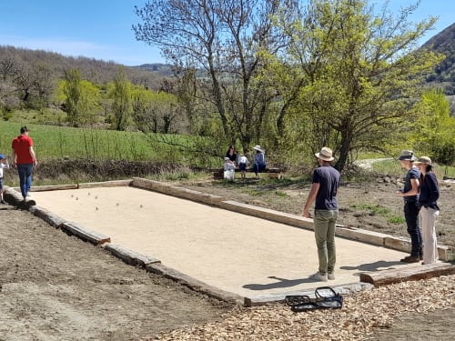 Guests playing pétanque at L'Amiradou B&B in Félines-sur-Rimandoule with scenic countryside views