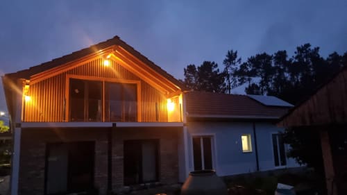 Eco Charm Discovery villa in Leiria, Portugal, illuminated at dusk with modern architecture and surrounded by pine trees