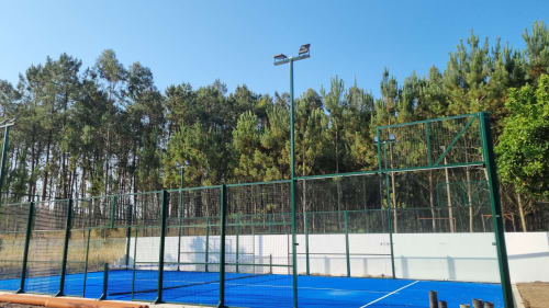Blue padel court with green fencing at Eco Charm Discovery Quinta da Oliveirinha villa in Leiria, Portugal