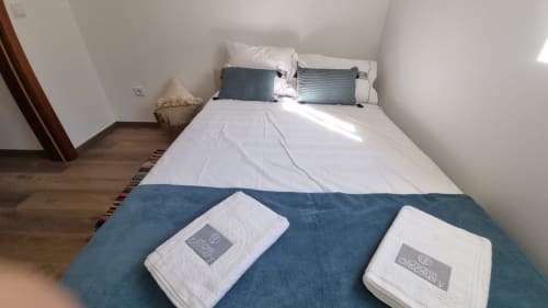 Cozy villa bedroom at Charm Discovery Quinta da Oliveirinha in Leiria with white towels and blue accents