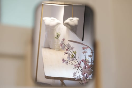 Camera moderna dell'hotel Cuore di Rocca a Rocca di Papa con cuscini bianchi, delicati fiori rosa e illuminazione calda