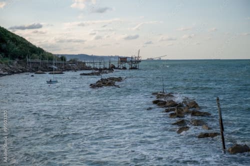 Insenatura rocciosa dell'Adriatico con barche da pesca e strutture in legno vicino ad Atessa, Abruzzo, Italia