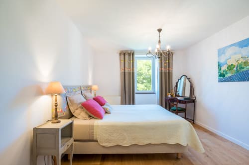 Chambre lumineuse à la Maison d'hôtes L'Amiradou à Félines-sur-Rimandoule avec literie blanche, oreillers roses et vue sur la campagne