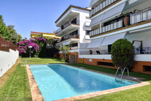 Shared swimming pool with loungers at Finques Garcia Enrich apartment complex in Palafrugell, Spain