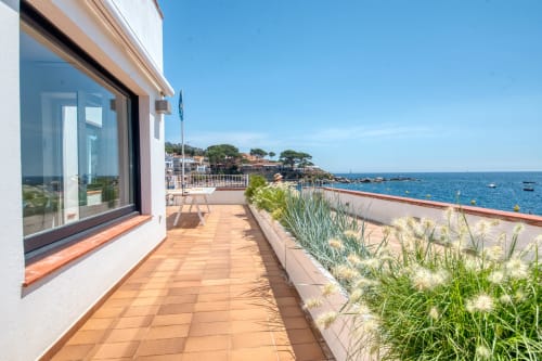 Terrasse en bord de mer chez Finques Garcia Enrich à Palafrugell avec vue sur la mer, fenêtres modernes et végétation méditerranéenne